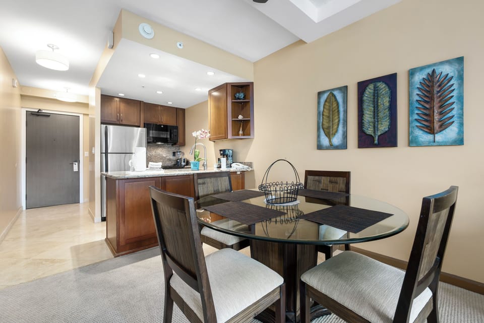 Gather around the elegant glass-top dining table, where shared meals become cherished memories. The fully equipped kitchen invites you to prepare your favorite dishes in style.