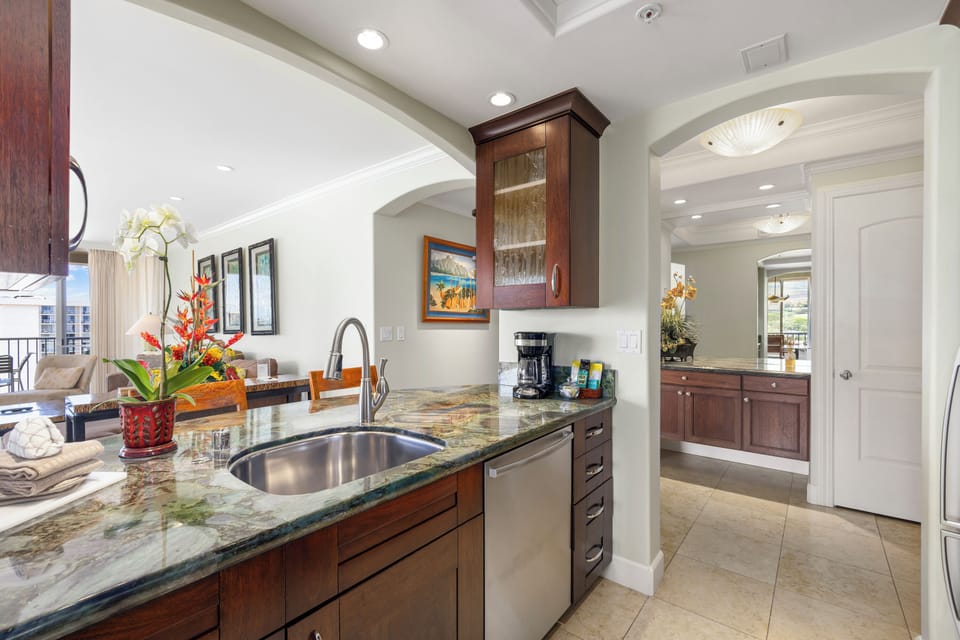 Prepare your meals at the granite countertop with a modern sink and dishwasher, surrounded by warm wood cabinetry and thoughtful touches throughout.