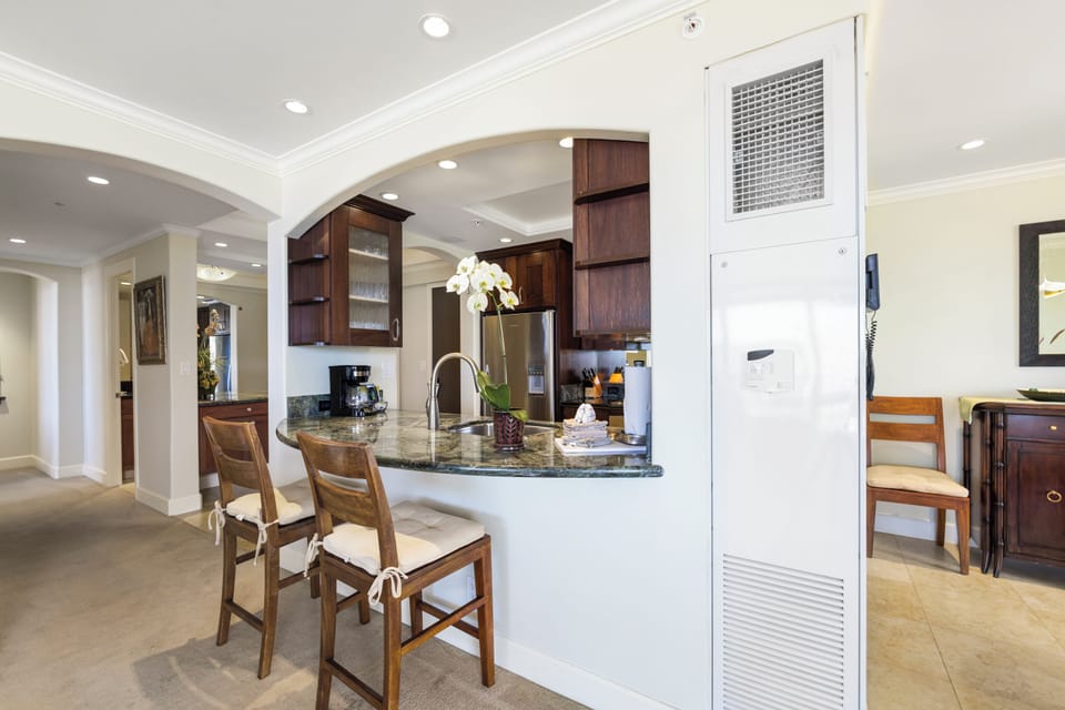 Step into a welcoming open kitchen with elegant granite countertops, rich wood cabinetry, and bar seating where you can sip your morning coffee in style.