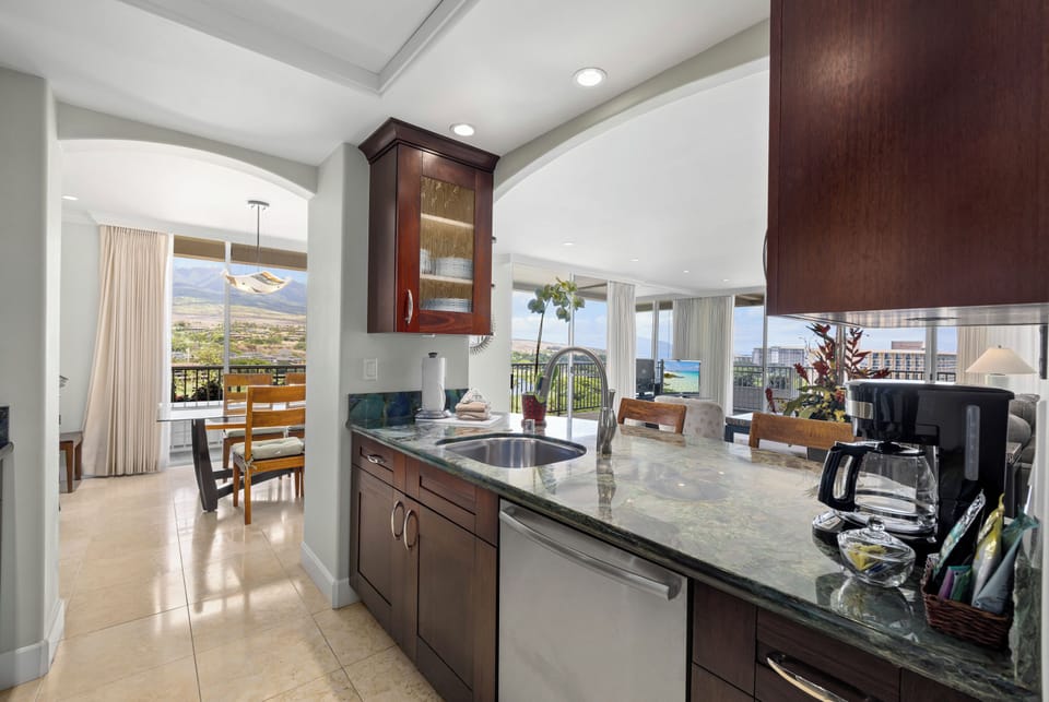 Your sleek, fully equipped kitchen invites you to prepare meals while soaking in stunning mountain and valley views through floor-to-ceiling windows.