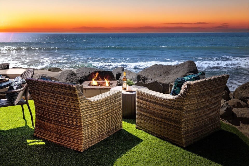 Beachfront fire pit seating creates the perfect oceanside retreat for evening gatherings with stunning sunset views.