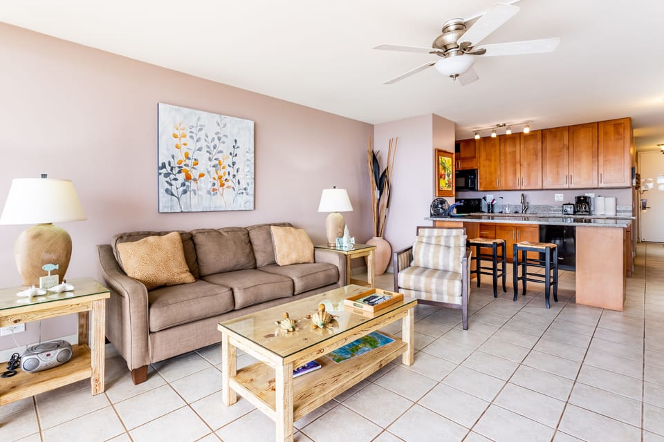 Relax in your open-concept living space, where a cozy sofa invites unwinding after a day of adventure, while the fully equipped kitchen makes preparing meals effortless and enjoyable.