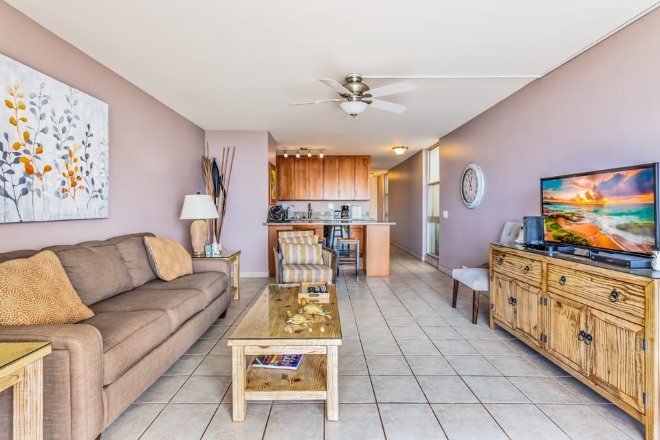Relax in your bright, open living space featuring coastal-inspired décor, comfortable seating, and a ceiling fan to keep you cool after a day of adventure.