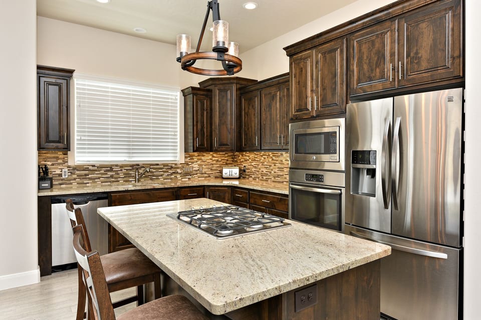 Kitchen Side View - Side view of kitchen showing off the beautiful counter tops and stainless-steel appliances.
