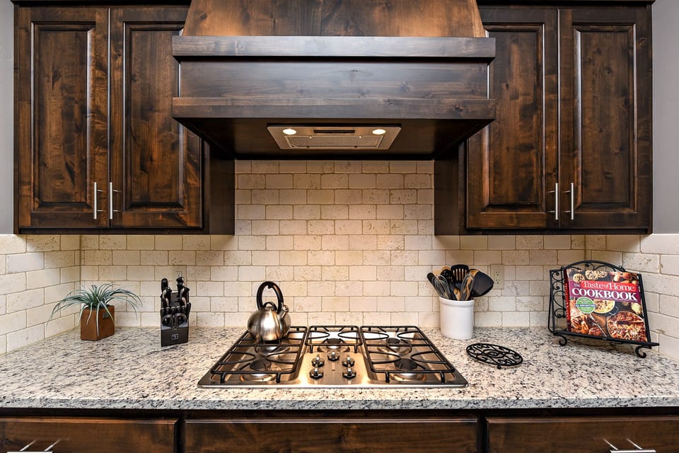 Kitchen Stove - The Kitchen Stove includes five burners and features an elegant hood and fan.