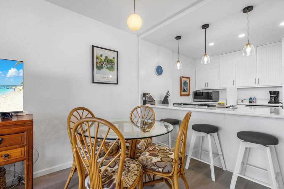 Gather around your coastal-inspired dining area and sleek breakfast bar, where modern lighting and a fully equipped kitchen make every meal feel special.