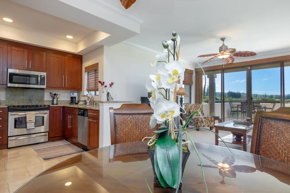 Open living space flows from kitchen to dining to your private lanai, where tropical breezes and lush green views frame every moment of your Hawaiian escape.