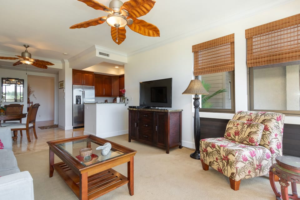 Relax in your island-inspired living space with tropical ceiling fans, bamboo shades, and a comfortable seating area perfect for unwinding after beach adventures.