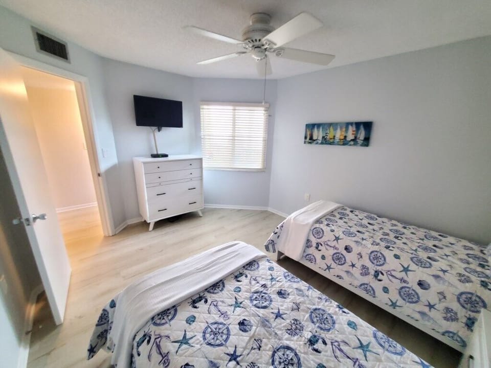 Fresh and airy twin bedroom with nautical theme, perfect for kids or friends.