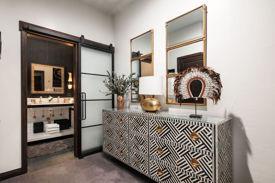 The main room with black and white dresser and stylish decor with gold accents.