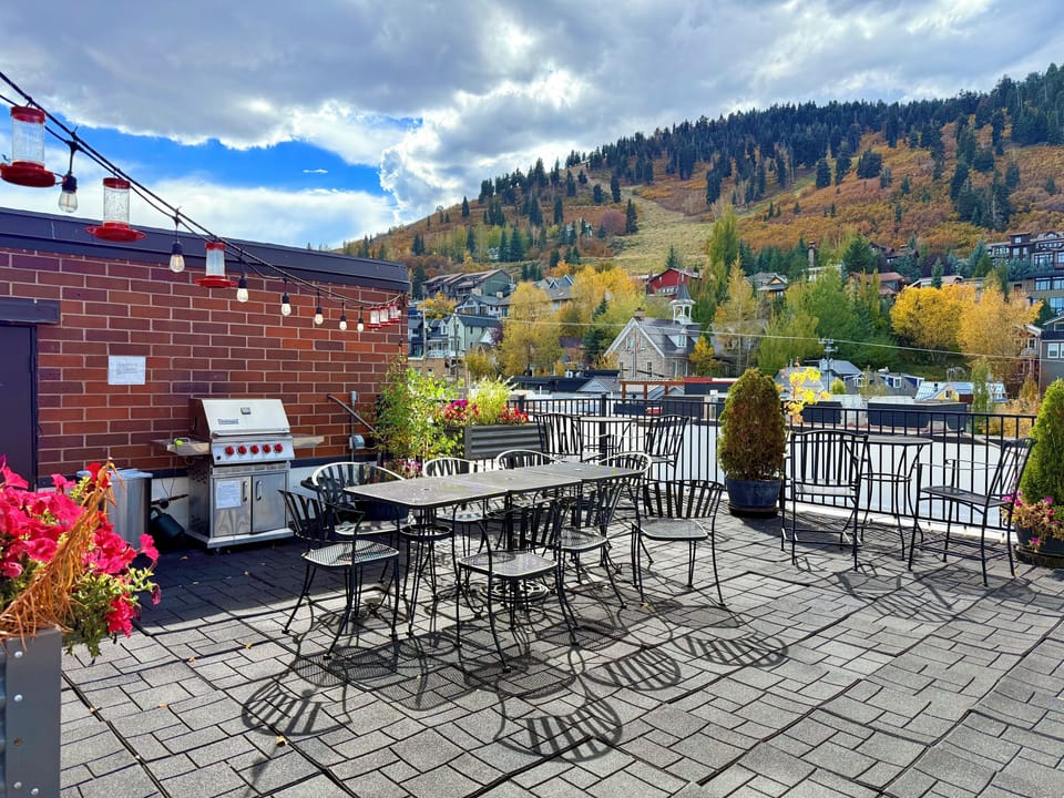 Shared Galleria rooftop with outdoor dining, barbecue grill, colorful flowers, and scenic Park City mountain views.
