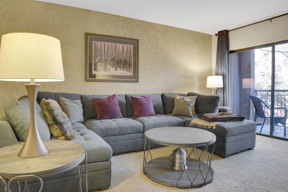 Park Station 122's living room has a grey upholstered sofa, throw pillows, modern round coffee table, and 2 lamps.Park Station 122's living room has a grey upholstered sofa, throw pillows, modern round coffee table, and 2 lamps.