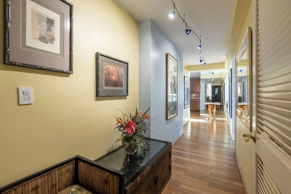 Hallway from the front door of the condo with bedrooms on either side of the hall, and the kitchen and living room at the end of the hall
