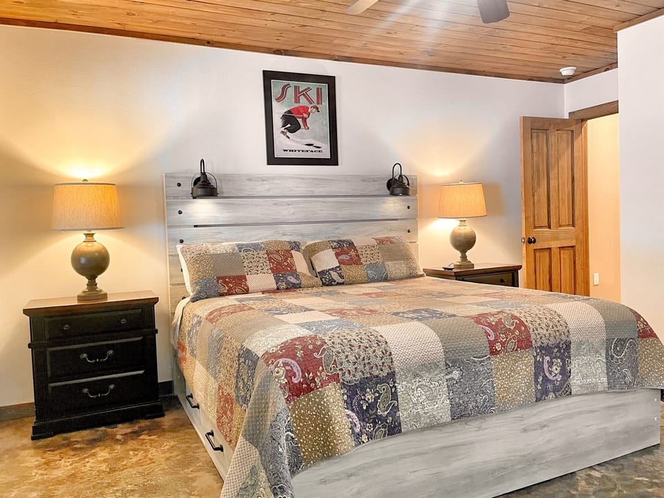 Lower level bedroom 5 features a King bed, door to outside, and beautiful decor.