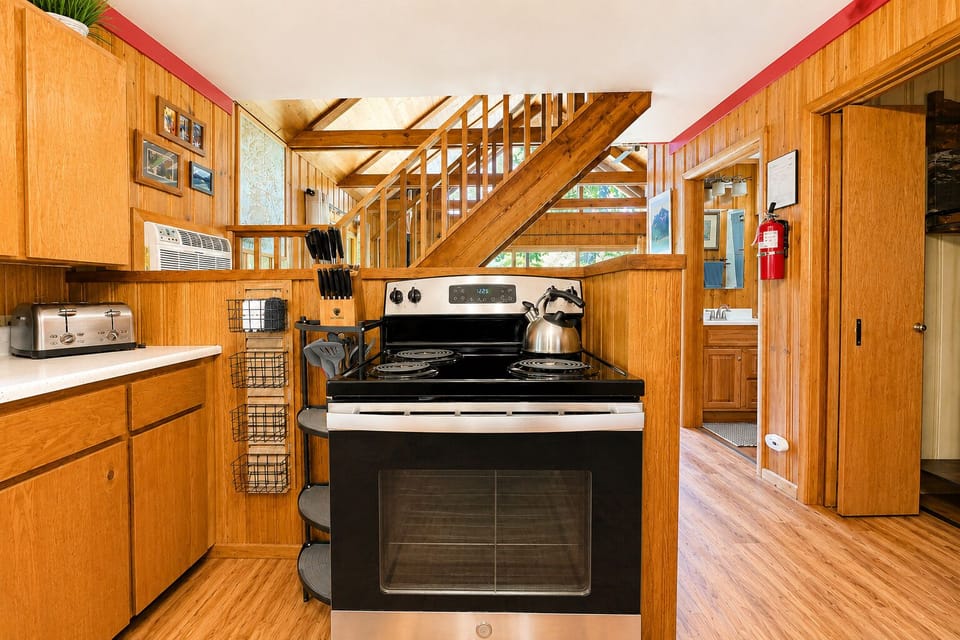 Your fully-equipped kitchen features modern appliances and warm wood finishes, with a cozy staircase leading to your private upstairs retreat—perfect for preparing meals and relaxing.