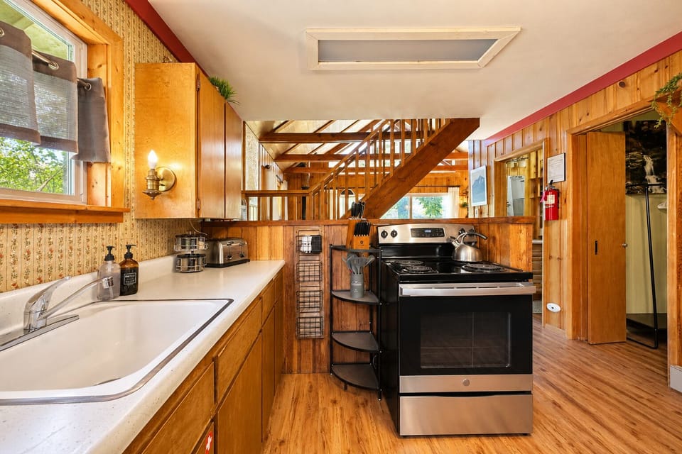 Step into your fully-equipped kitchen with warm wood cabinetry, modern appliances, and a cozy loft-style layout. The skylight floods the space with natural light, making meal prep feel effortless and inviting.