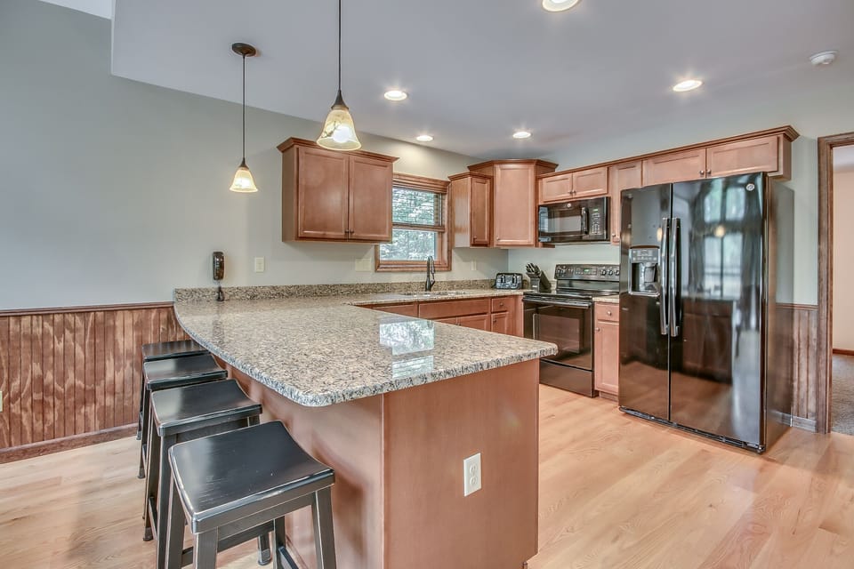 Alternate Angle of On The Rocks Kitchen with Seating, Fridge, and Open Floor Plan