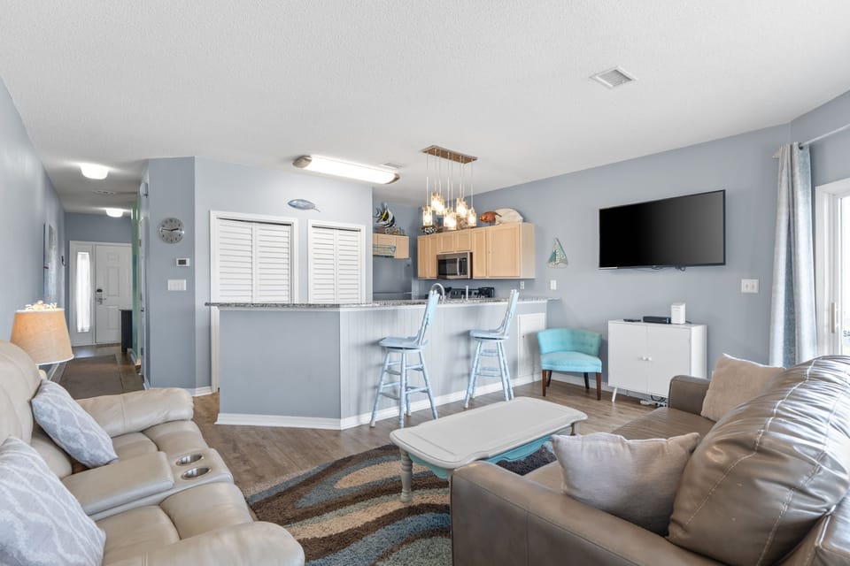 Relax in your spacious living area with plush seating and open kitchen design, perfect for unwinding after beach days.
