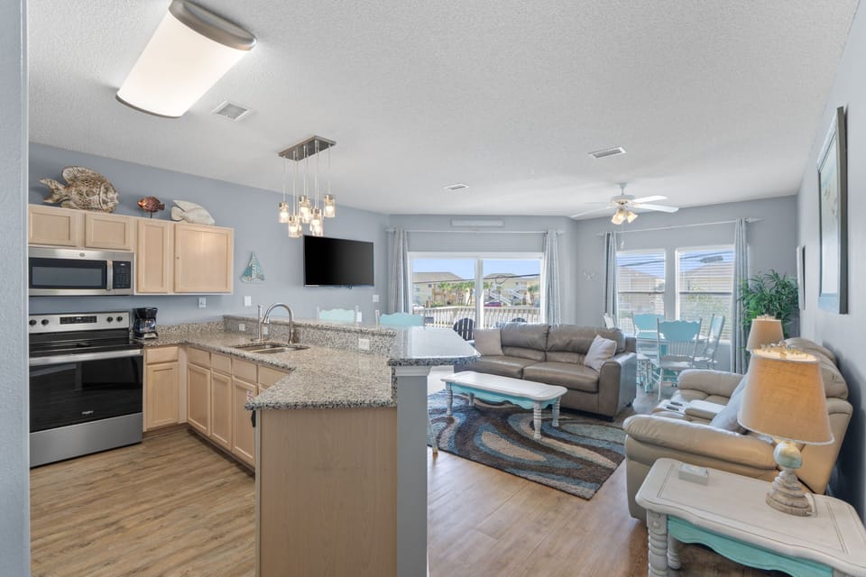 Relax in your open-concept living space where the modern kitchen flows into comfortable seating, perfect for gathering with family and friends.
