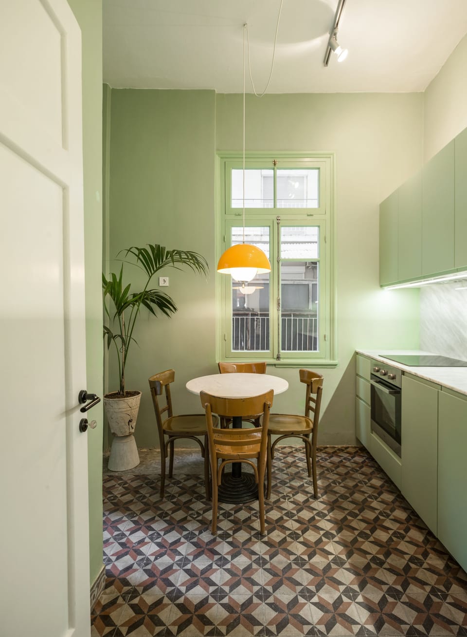 The kitchen has a balcony with neighborhood view