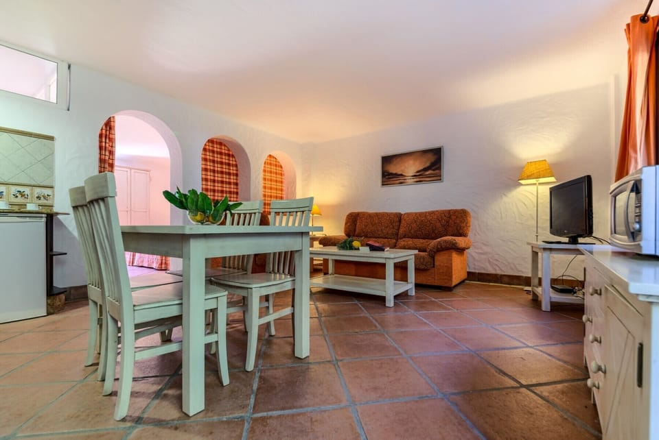 Table, sofas and TV of Lavanda and Romero apartments in Hacienda Roche Viejo in Conil