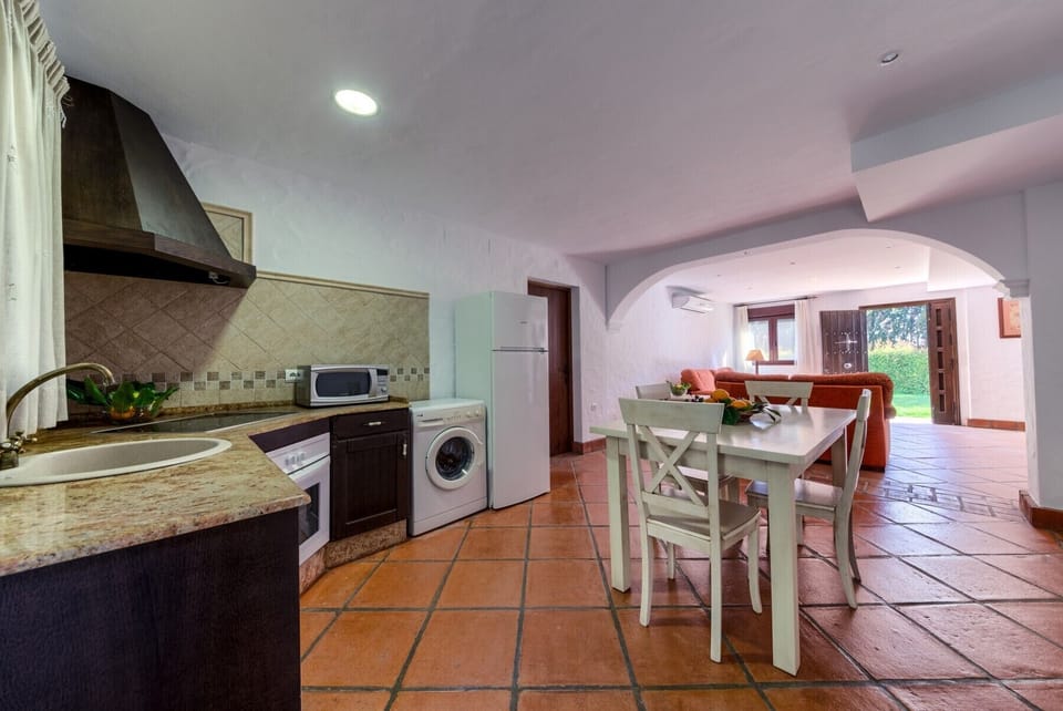 Countertop, table and chairs of Hierbabuena apartment kitchen in Hacienda Roche Viejo in Conil