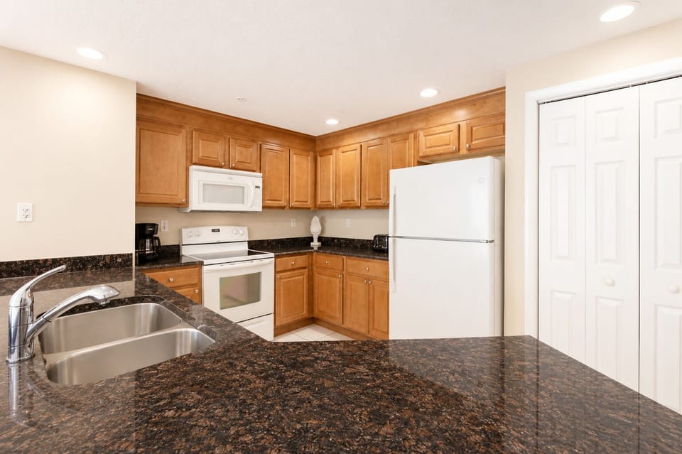 Your fully equipped kitchen features granite countertops, warm wood cabinetry, and modern appliances—everything you need to whip up breakfast before exploring or unwind with a home-cooked meal.