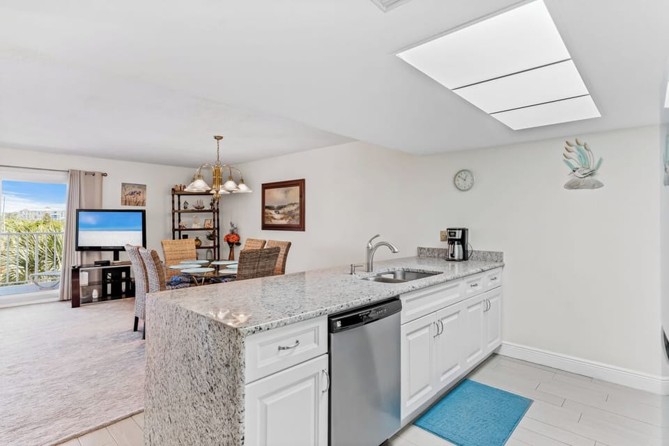 Your spacious kitchen flows seamlessly into the dining area, where granite counters and stainless appliances make cooking effortless while you enjoy natural light streaming through skylights.