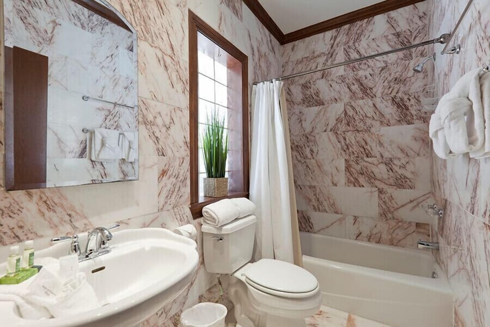 Natural light and unique tiling will surprise you in the bathroom suite of the lower level primary bedroom.