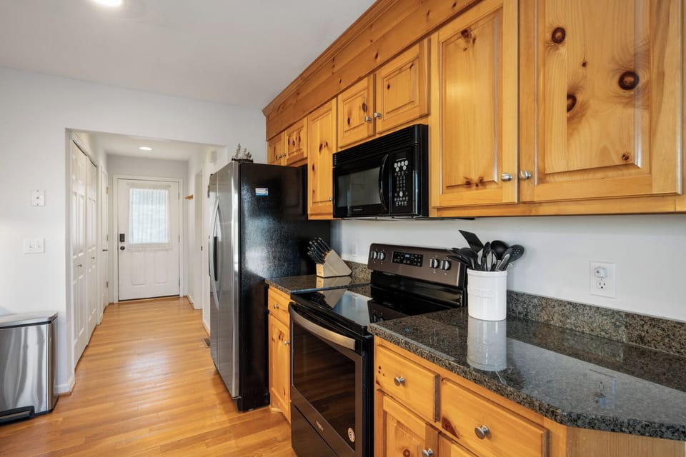 Whip up your favorite meals in this fully equipped kitchen with granite counters, stainless appliances, and warm wood cabinets.