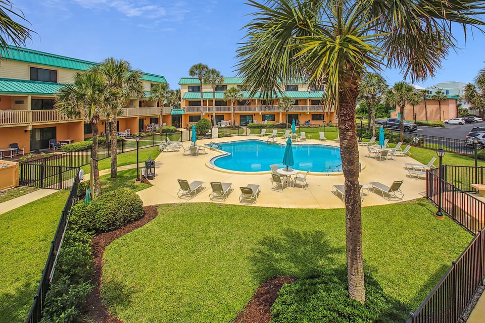 - Resort-style pool surrounded by palm trees and lounge seating for relaxation  
- Clear blue water ideal for swimming, sunbathing, and family fun together  
- Scenic setting steps from the ocean creates a perfect vacation experience 