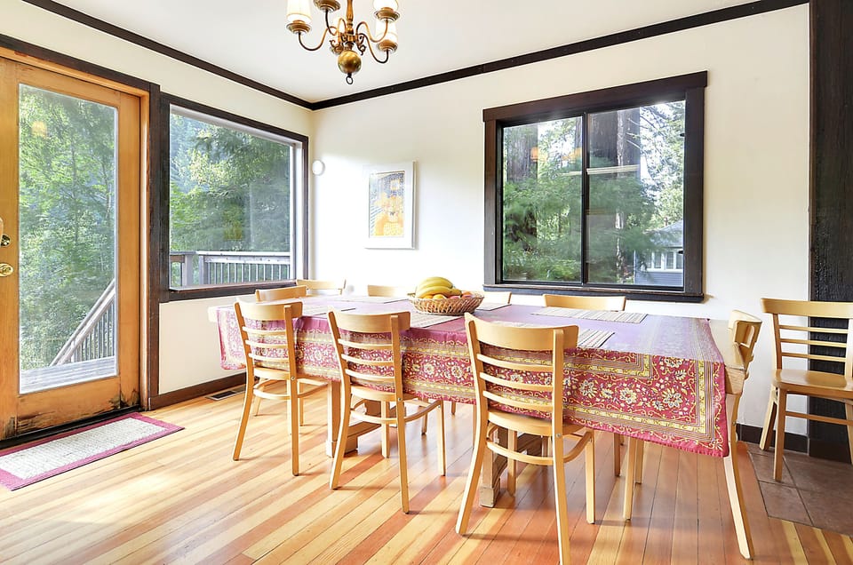 The dining table comfortably seats 8 people with views of the redwood trees and doors to the decks.