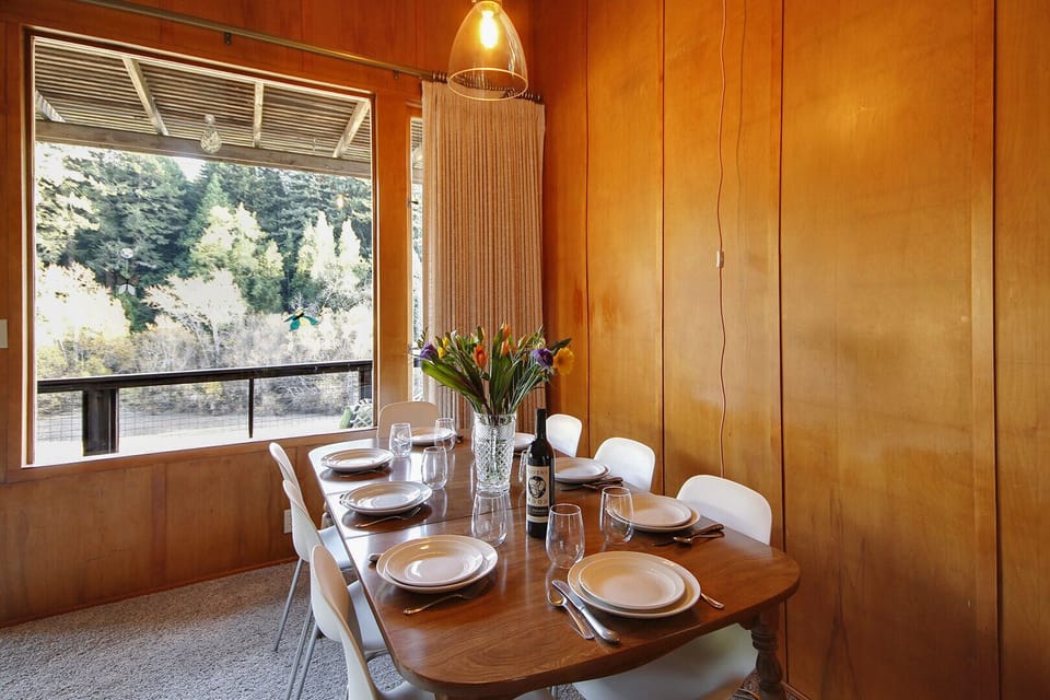 The dining table has a river and is open to the living room.