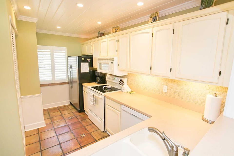 - Bright fully equipped kitchen with white cabinets and modern appliances  
- Features fridge, stove, microwave, and dishwasher for convenience  
- Perfect for cooking meals and enjoying a comfortable stay
