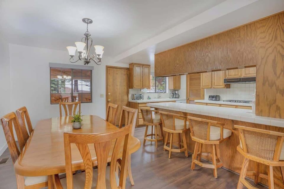 Dining Room separated from Kitchen by Breakfast Bar with 4 swivel bar chairs
