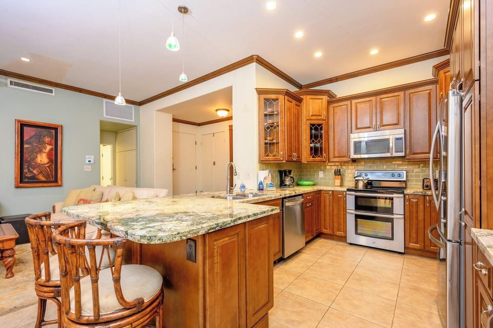 Elegant kitchen with granite countertops, stainless appliances, and warm cabinetry.   