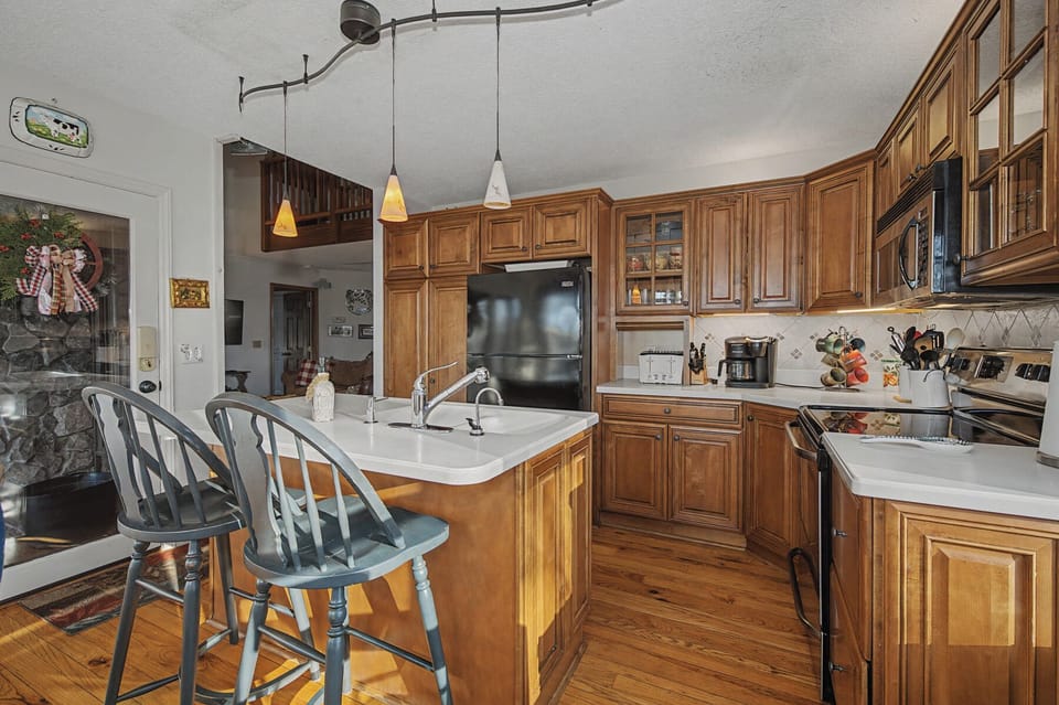 You'll love cooking in this spacious kitchen featuring warm wood cabinets, granite counters, and a breakfast island for casual meals.