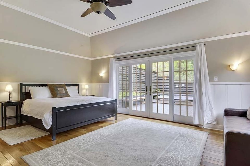 Primary Bedroom with French doors to the back deck and hot tub.