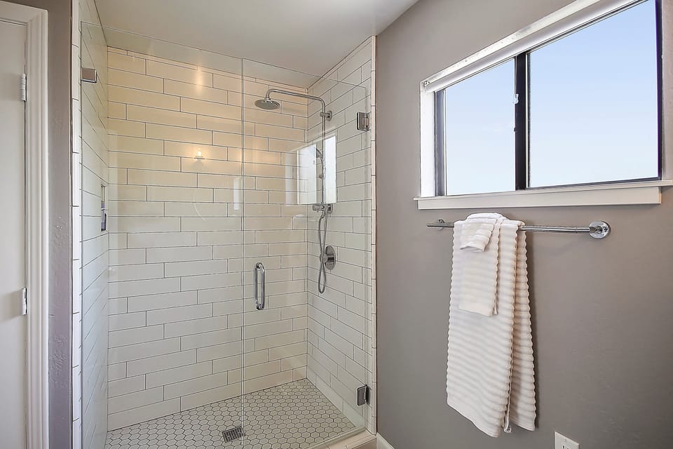 Main Level - full bathroom with custom tiled shower and rain-style showerhead.