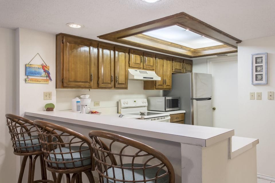 Entertaining in our open-floor plan condo is as easy as a walk on the beach thanks to our kitchen bar, full-size appliances, and ocean view!