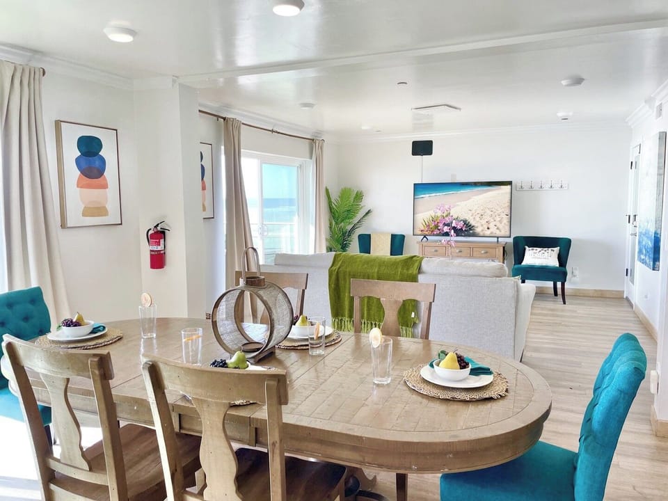 Gather around your spacious dining table while enjoying the coastal breeze through large windows in this bright, stylishly furnished living space.