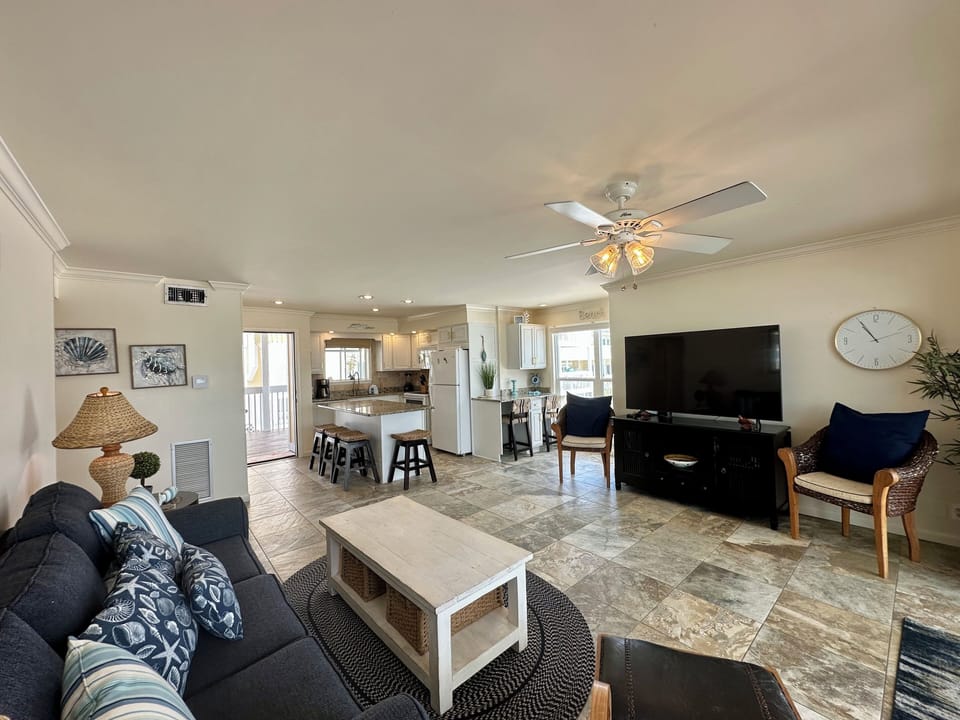 Relax in your spacious living room with coastal touches, open kitchen, and comfortable seating perfect for gathering.