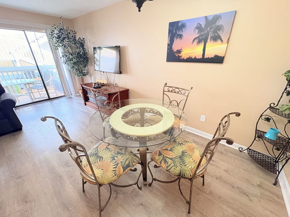 Gather around your elegant glass dining table where tropical artwork sets the mood for memorable meals with loved ones.