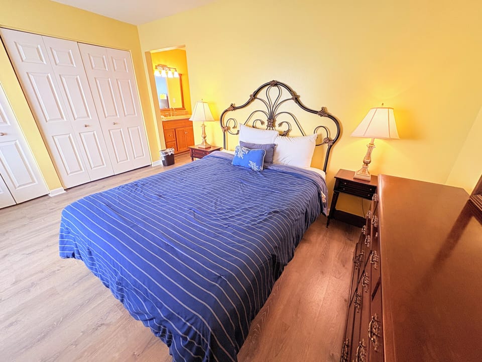 Sink into comfort in your elegantly appointed bedroom, where warm golden walls and a wrought-iron headboard create the perfect sanctuary for restful nights.