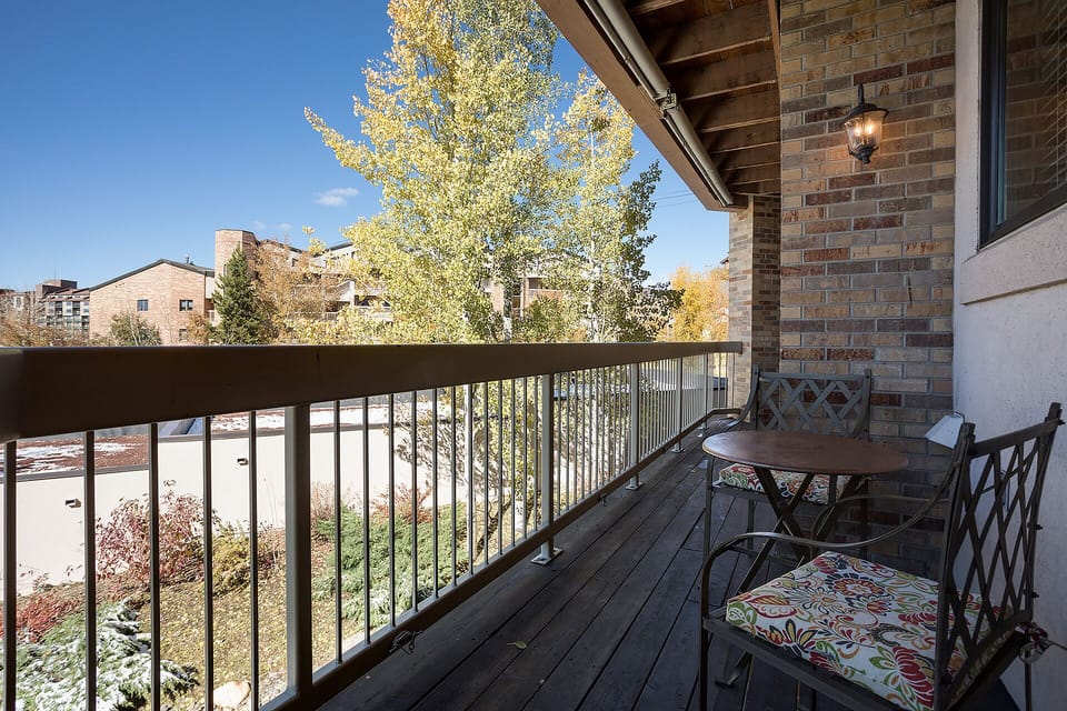 Step onto your private balcony to enjoy morning coffee at the bistro table while taking in peaceful neighborhood views and autumn colors.
