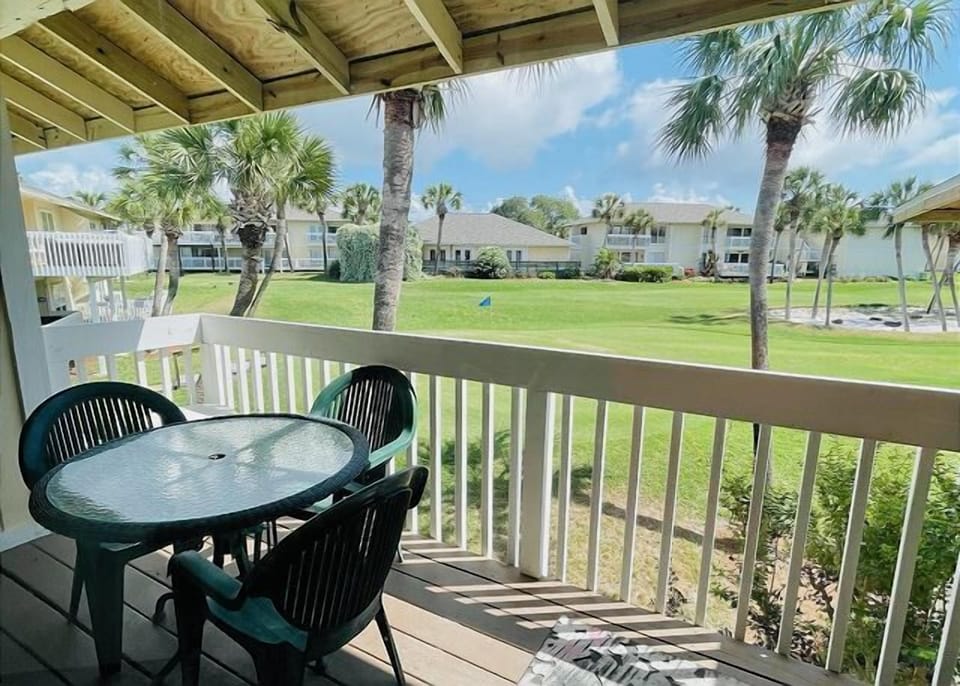 Your covered balcony overlooks lush tropical grounds with palm trees, perfect for morning coffee or evening relaxation in paradise.