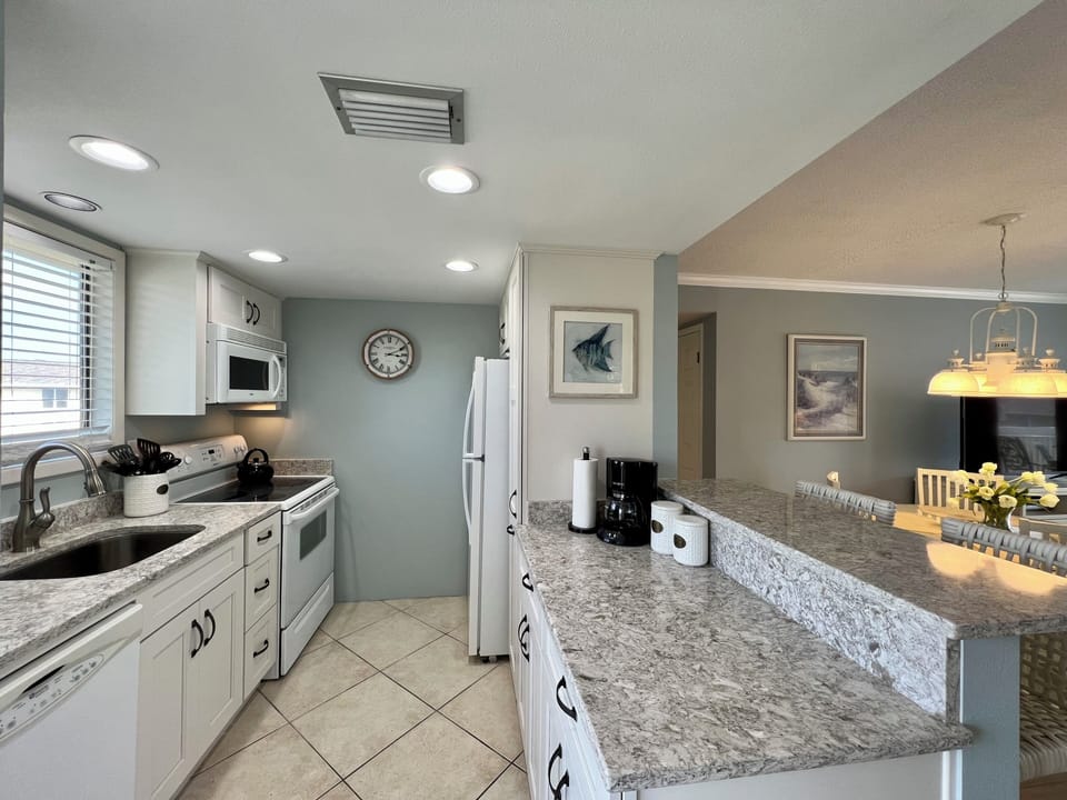 Cook with ease in your fully equipped kitchen featuring granite countertops, modern appliances, and an open layout that flows seamlessly into the dining area.