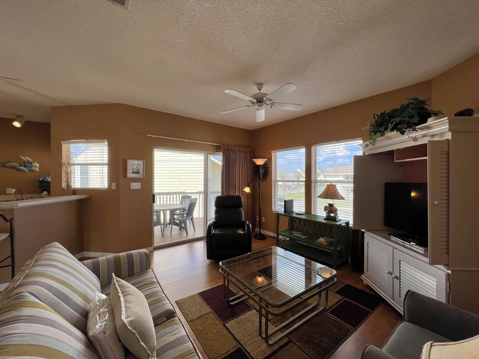 Unwind in your spacious living room with comfortable seating, entertainment center, and beautiful natural light streaming through large windows.