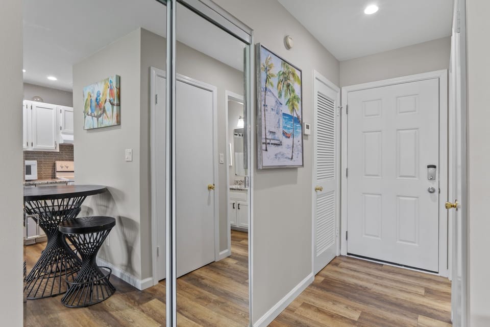 Step into your stylish entryway with mirrored closets offering ample storage and a convenient breakfast bar for morning coffee.