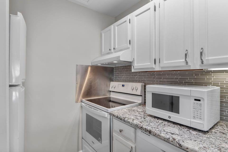 Your fully equipped kitchen features granite counters, modern appliances, and elegant tile backsplash for all your home-away-from-home cooking needs.